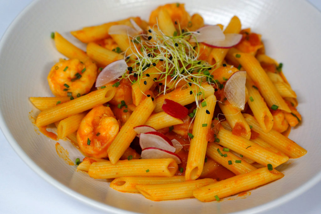 Penne aux crevettes surmontées de cresson.